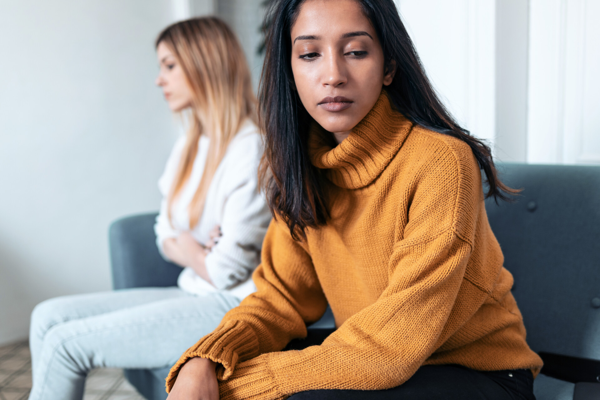 Friendship Breakup Two upset friends not talking to each other after fight on the sofa